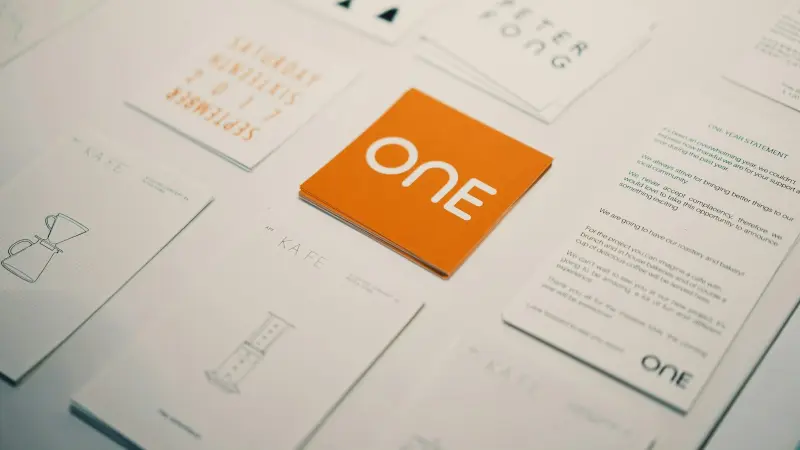 Orange Karte mit Logo zwischen hellen Visitenkarten