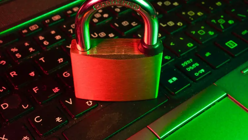 Rotes Vorhängeschloss auf einer schwarzen Computertastatur